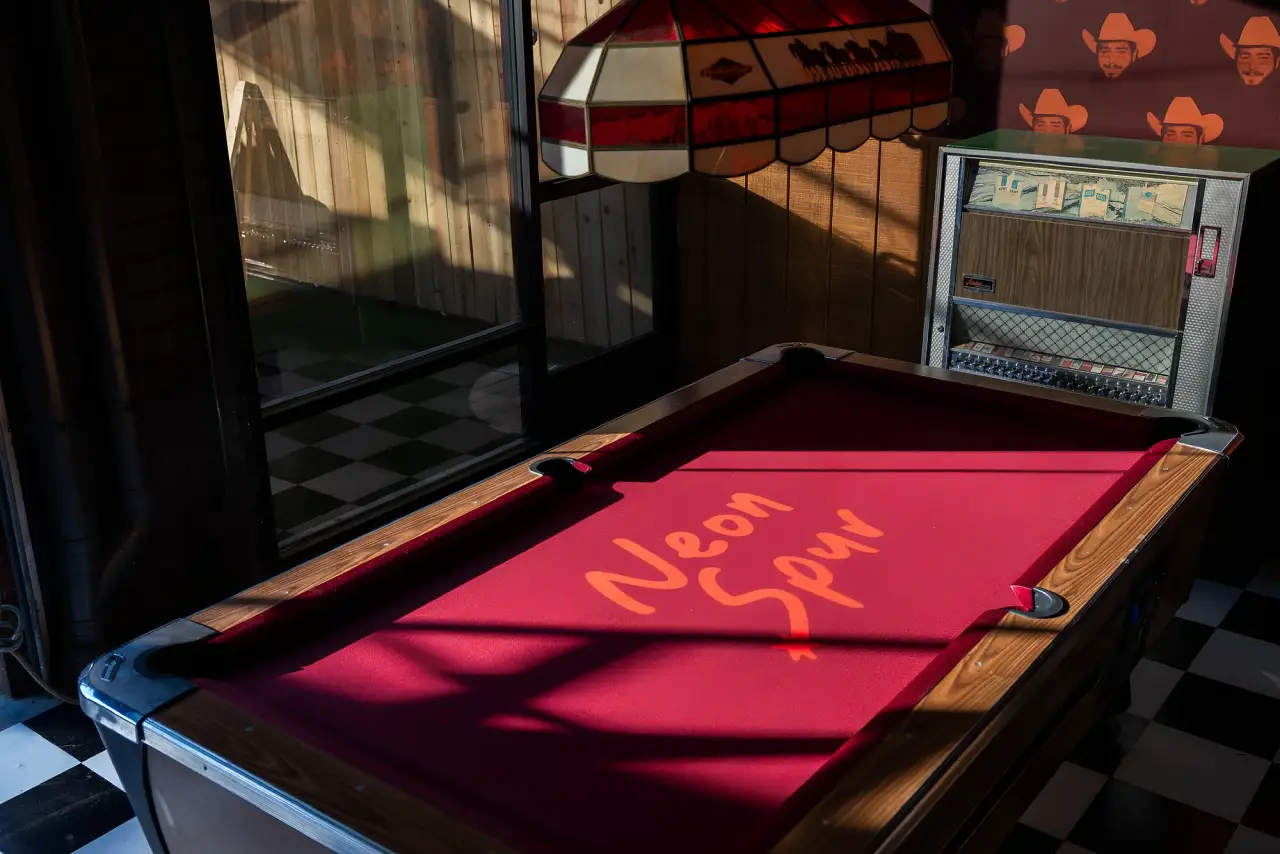 The red-felt pool table and jukebox at Neon Spur