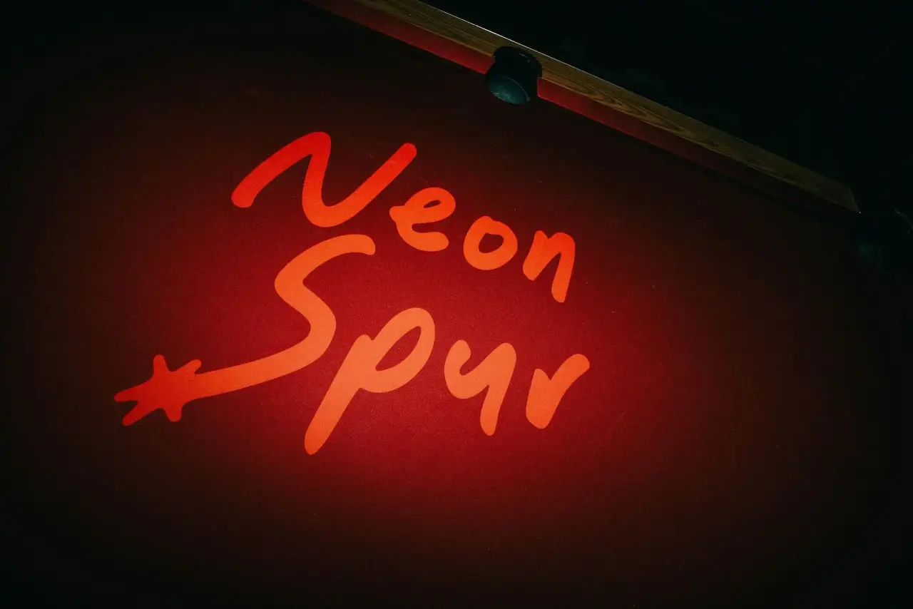 The Neon Spur sign glowing red