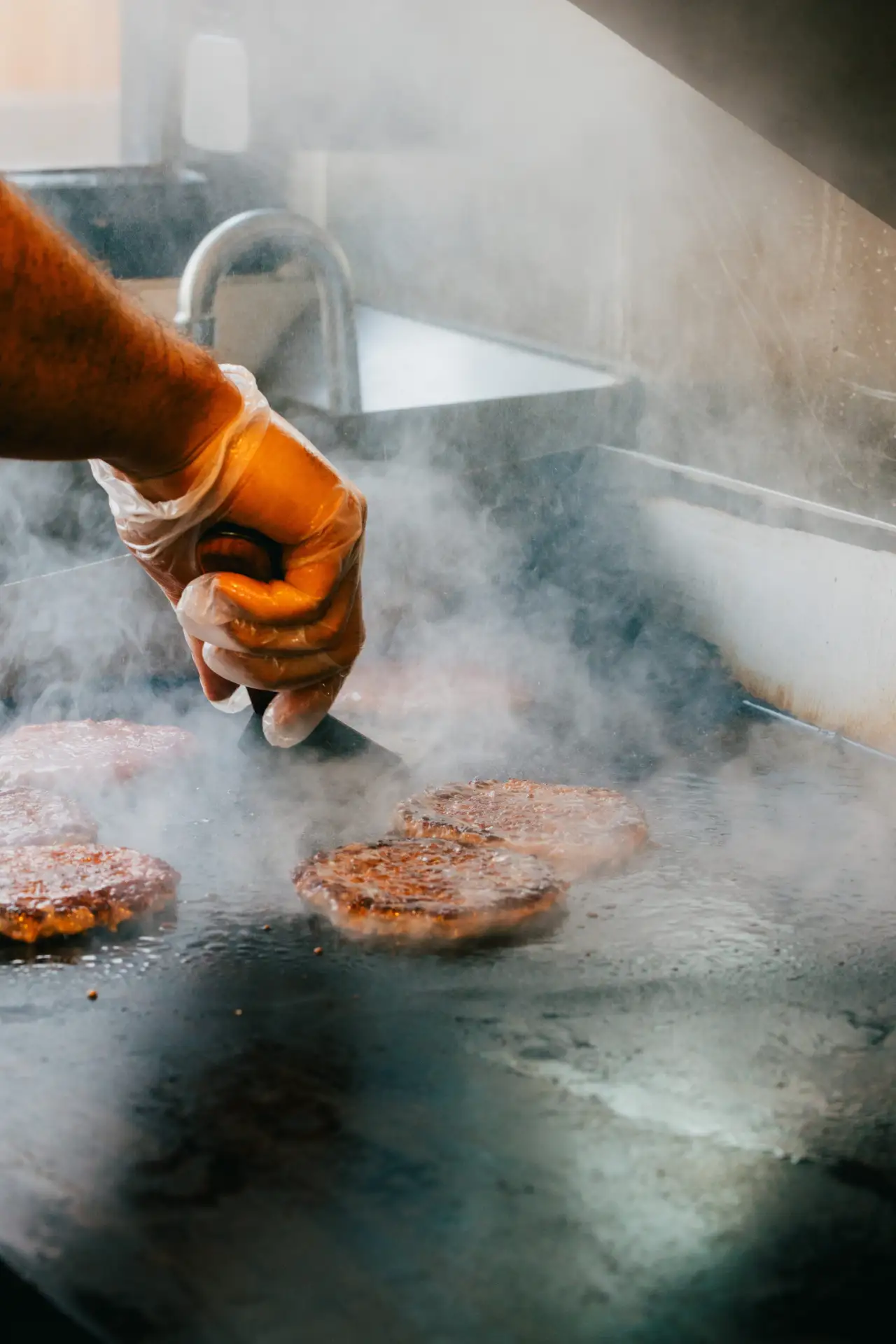 Smash patties searing on the flat-top grill